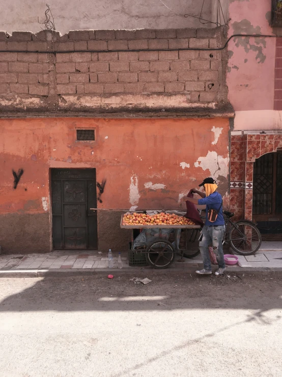 a person with a helmet on standing in front of a large pizza