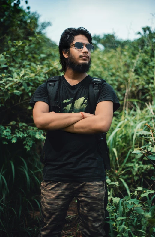 a man standing in a field with his arms crossed