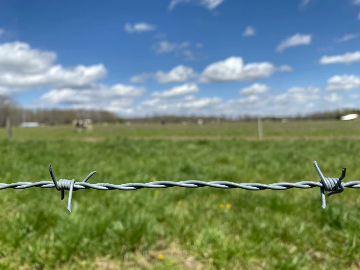 a fence in the foreground of a field