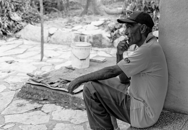 a black and white image of a man with his feet crossed