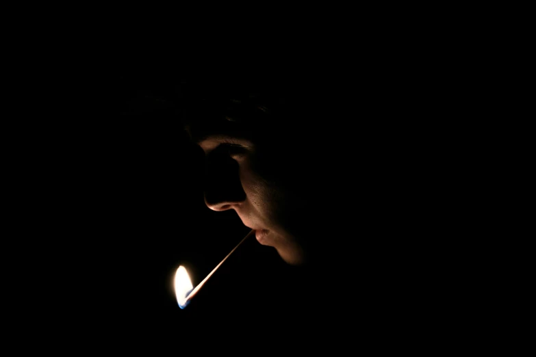 a woman smoking a candle in the dark