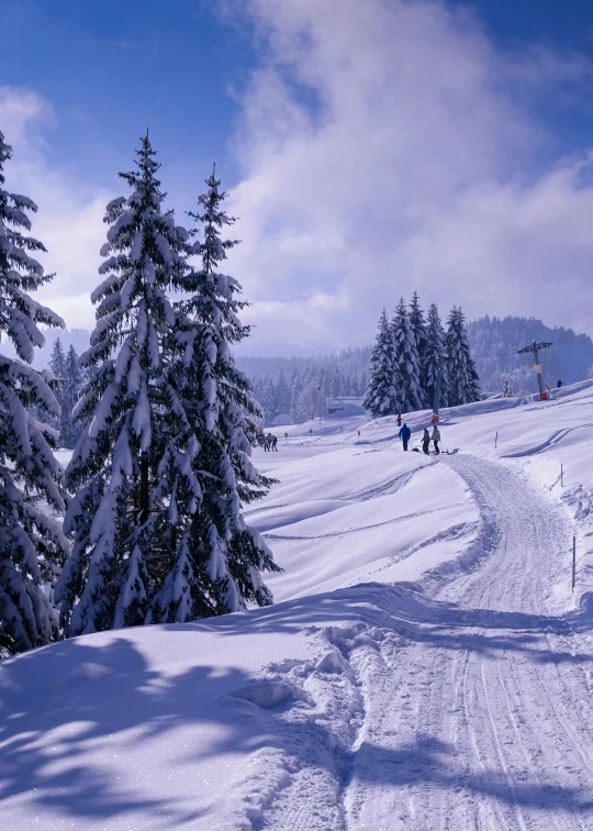 two people riding down the side of a snow covered slope