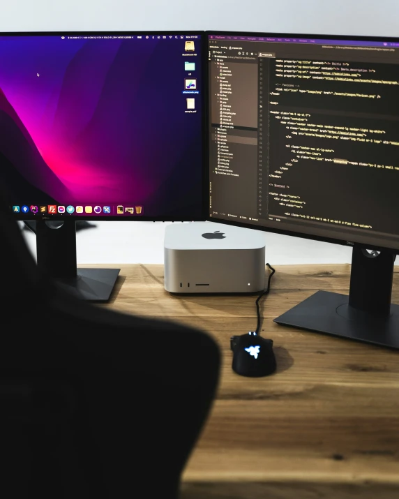 two computer screens and a mouse are on a desk