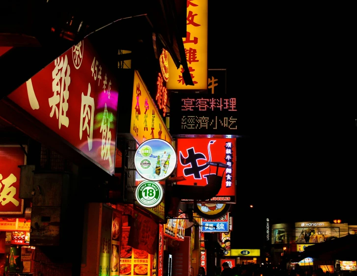 many signs and signs on the side of buildings in a city at night