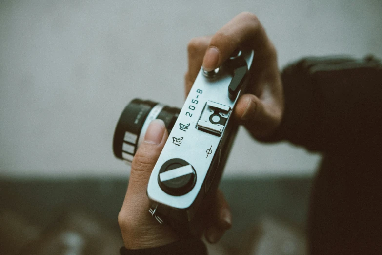 a person holds a camera with their fingers