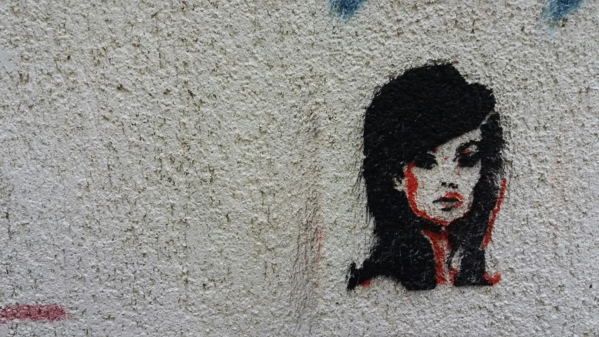 a painting of a girl in red is painted on the side of a building