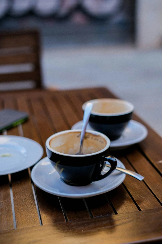 two cups of coffee on a wood table