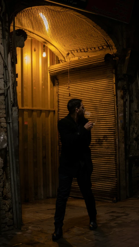 a man walks in front of an arched doorway