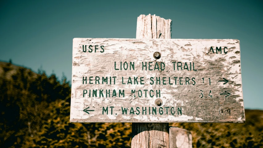 a sign giving directions in the mountains wilderness