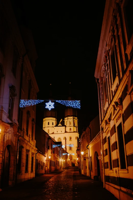 an empty street with buildings and christmas lights