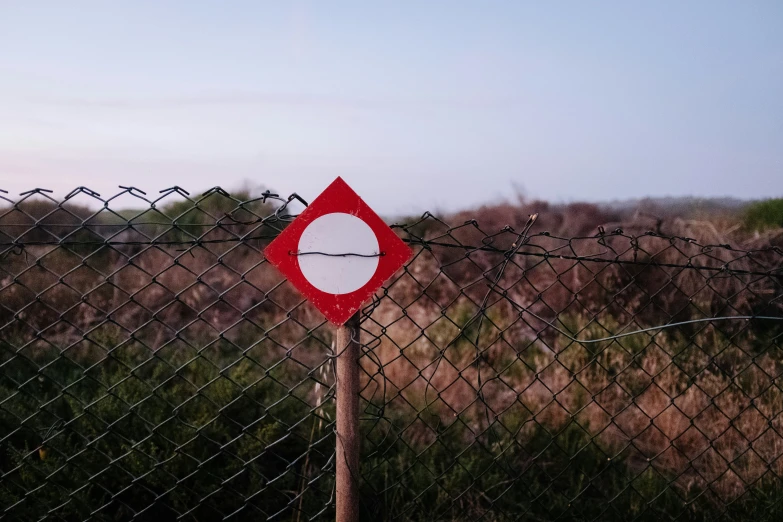 a sign is seen in front of a fence