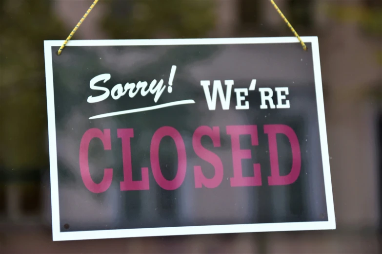 a closed sign posted on a glass door saying sorry we are closed