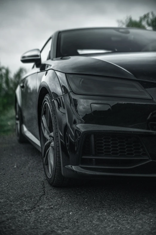 a black sport car is parked on a wet road