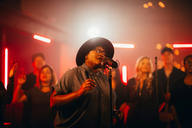 a male singer is in a large group with microphone