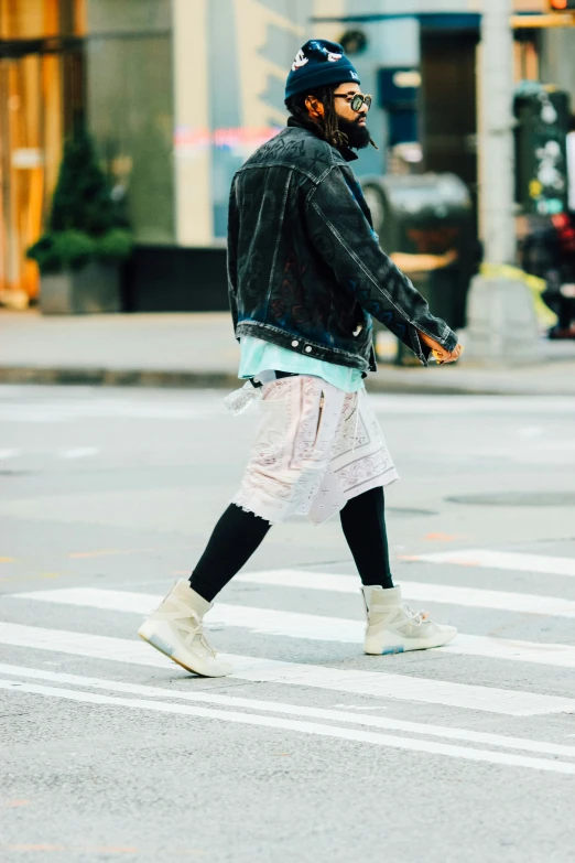 a man wearing glasses and a jacket crossing the street