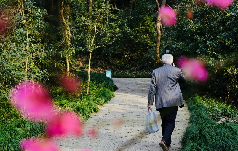 a person in a gray coat walking down a path