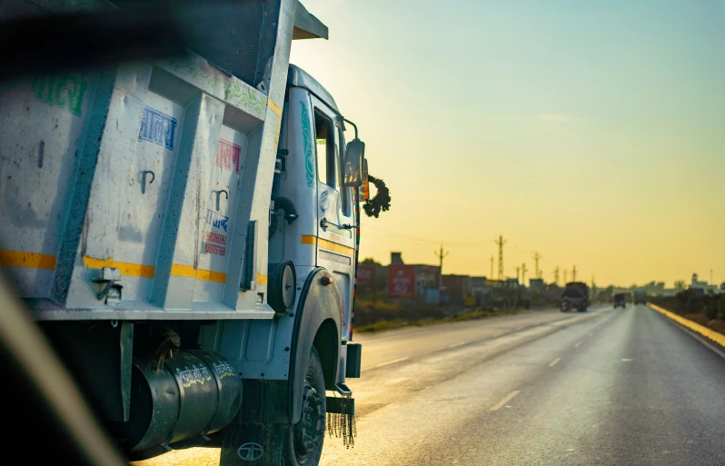 the back view of a truck and some other vehicles driving on the road