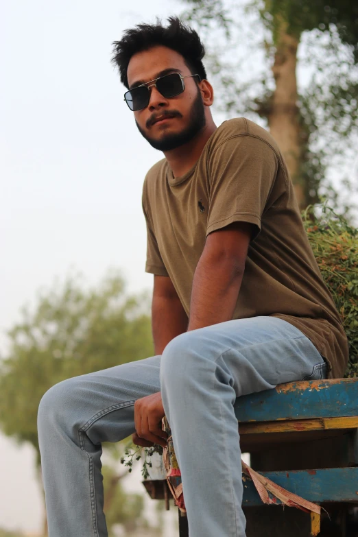 a young man is sitting on top of a wooden table