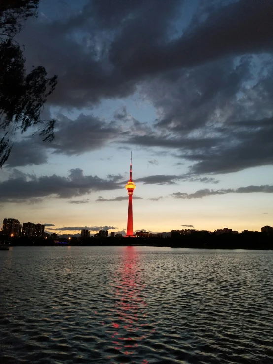 a tower with a clock on top is sitting alone in the water