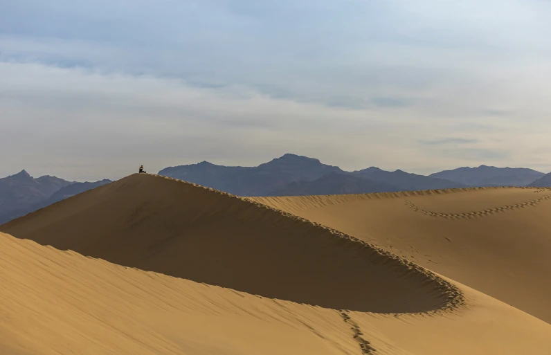 the person is walking on the sand dunes