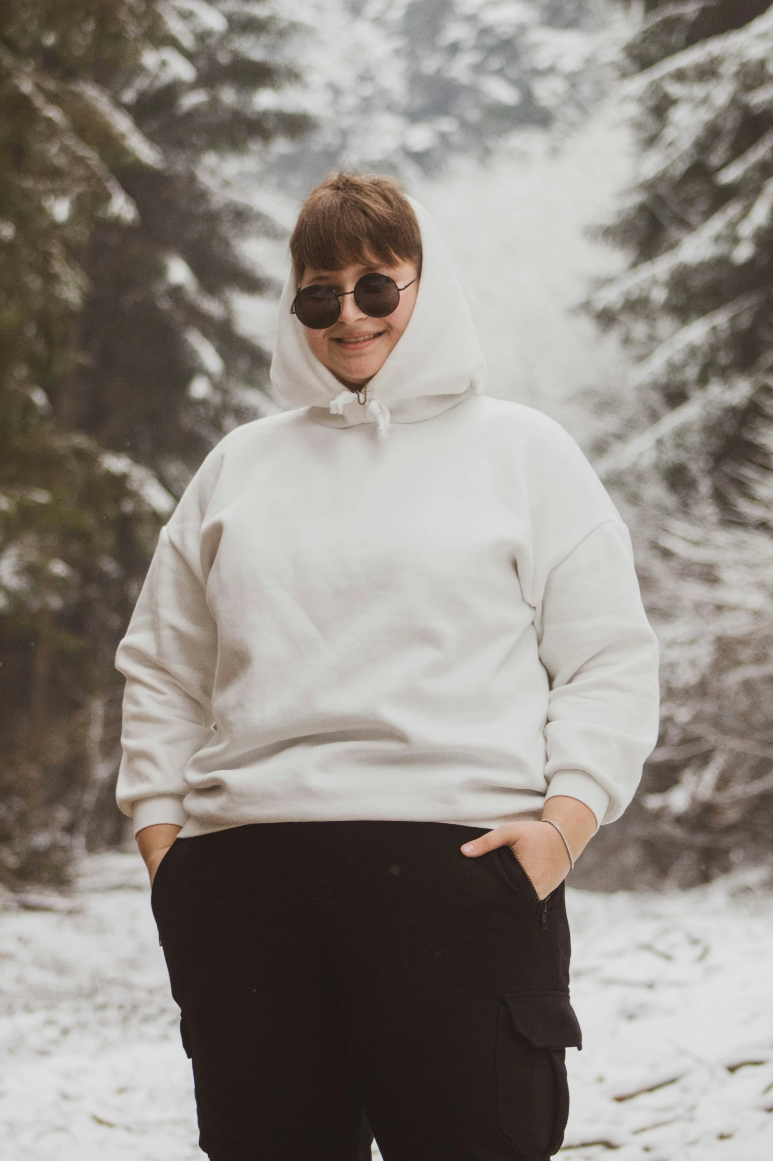 the girl with glasses is posing in the snow