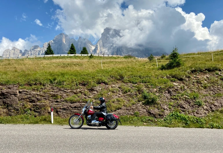 a motorbike parked on the side of a road in front of mountains