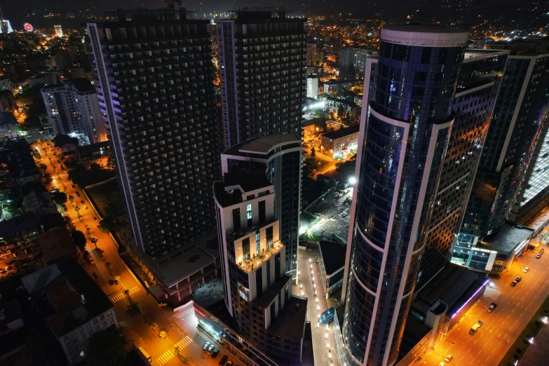 an aerial view of a city with some buildings at night