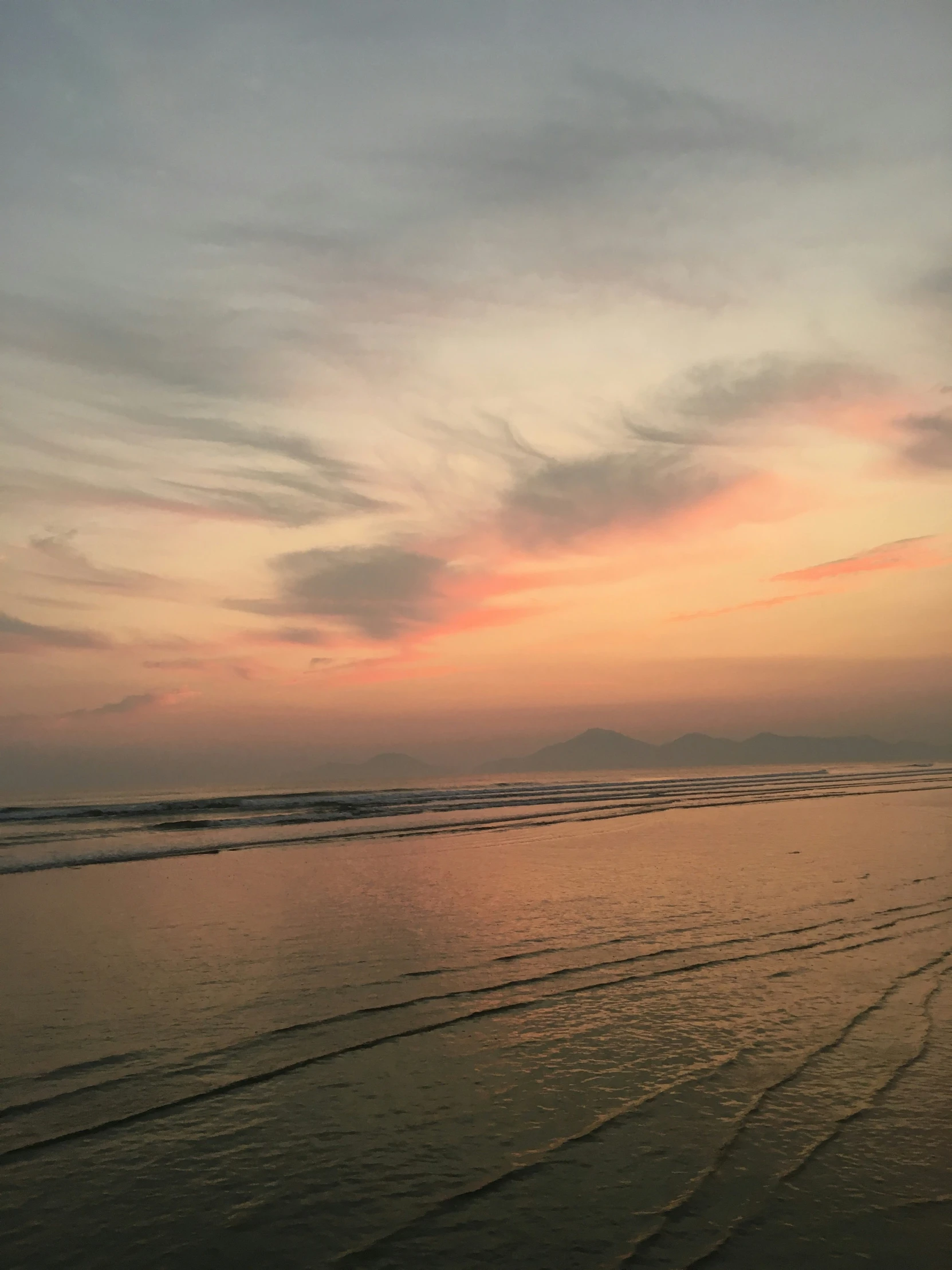 a person riding on the beach at sunset