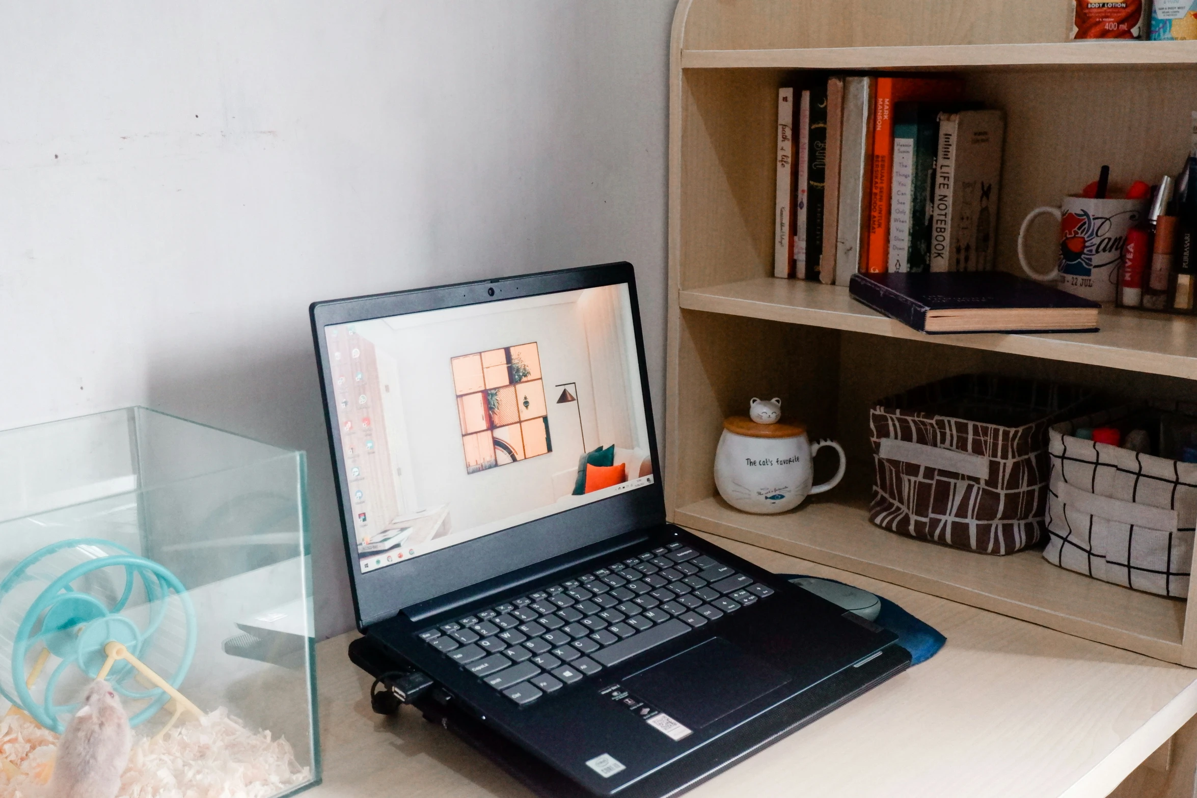 the laptop on the table is next to the glass case