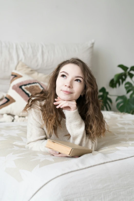 a woman is laying on her bed and smiling