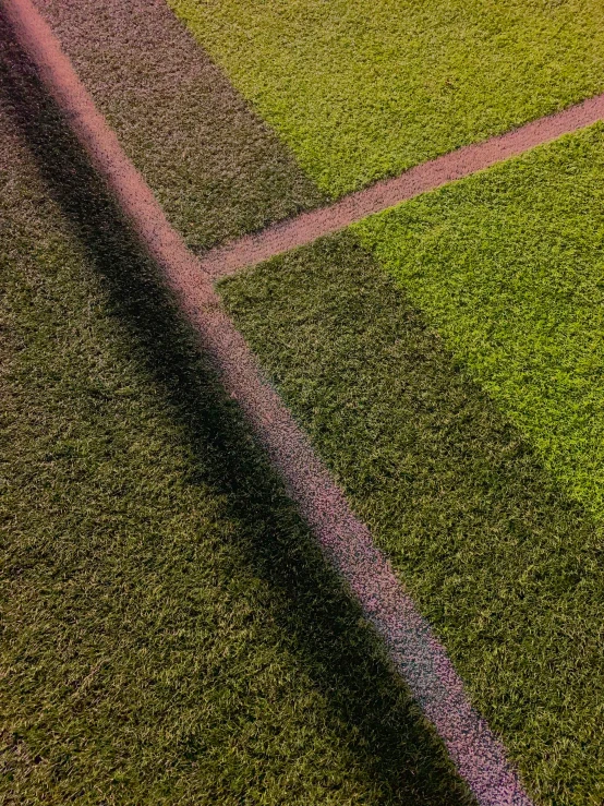 a shadow of a man's tennis racket on grass