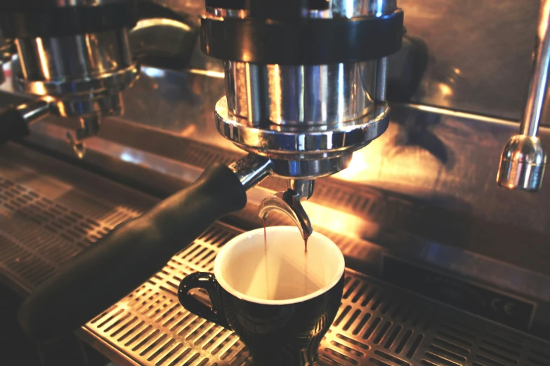 a cup being brewted in a coffee machine