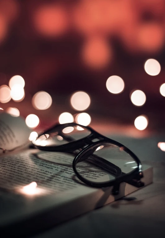 an open book and reading glasses are sitting on the table