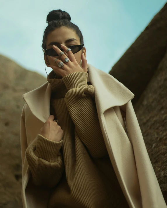 a woman with her hand to her mouth and a cellphone on her face