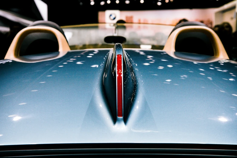 the front of an old blue sports car in front of a building