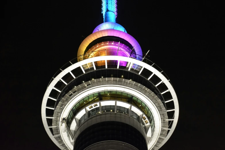 an odd shaped building with a rainbow light on top