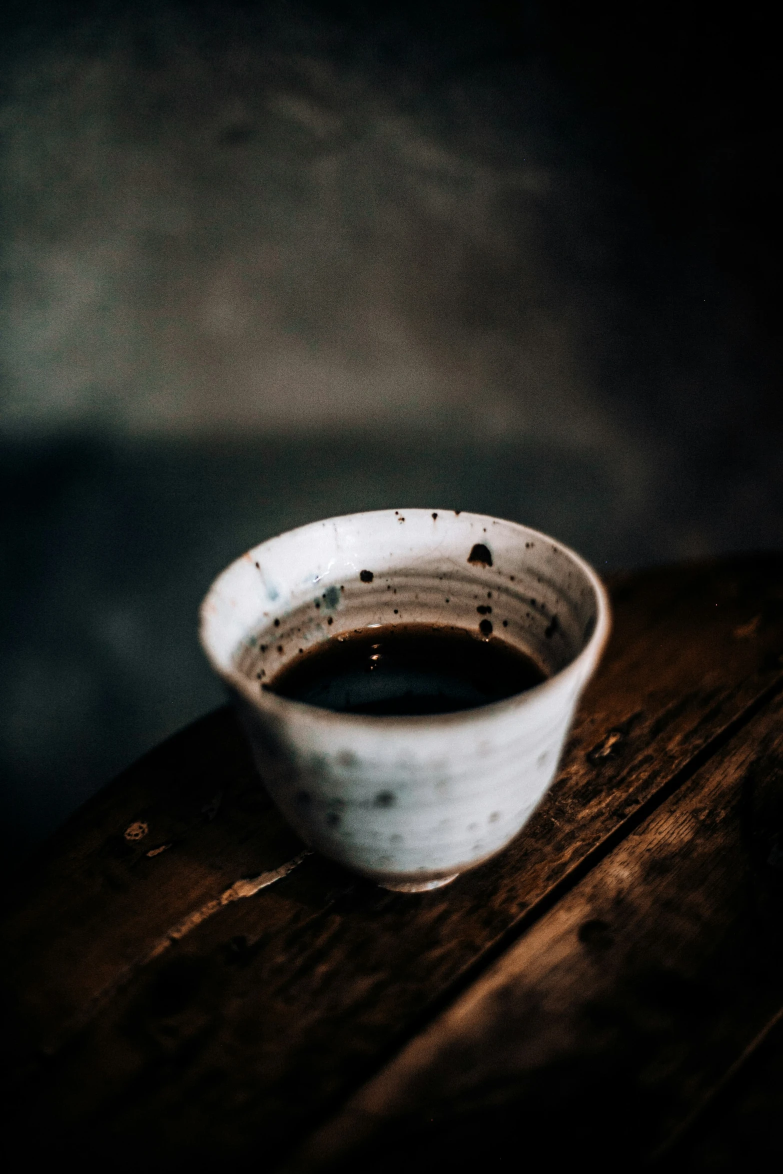 a white bowl filled with liquid sitting on top of a wooden table