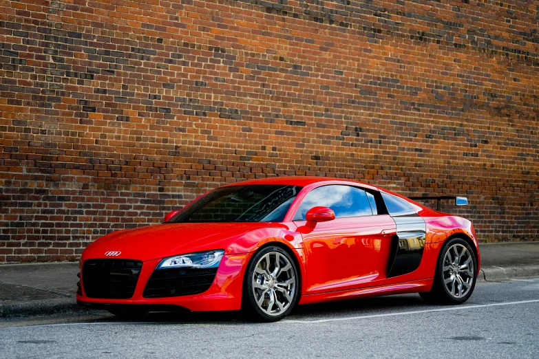 the red sports car parked near a brick wall