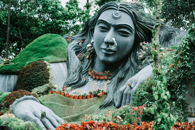 large statue of god is in flower garden