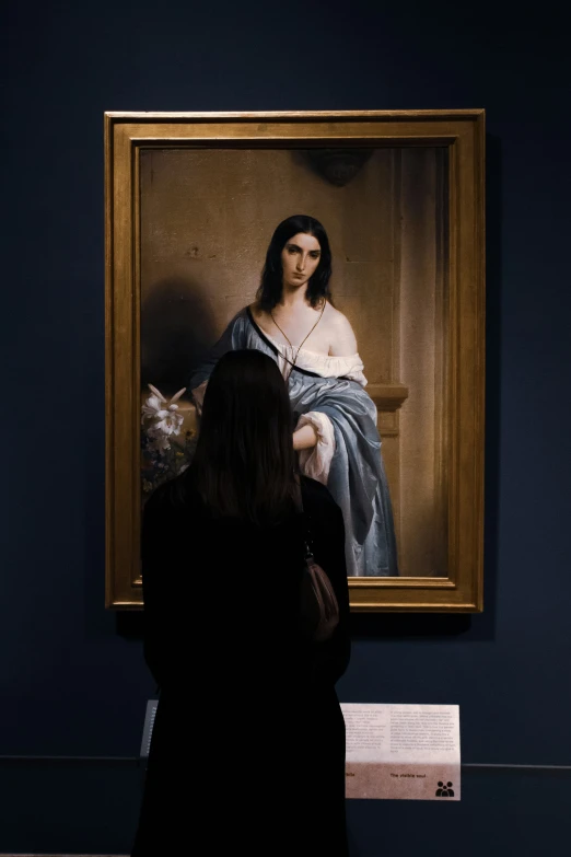 a woman looking at a portrait of jesus