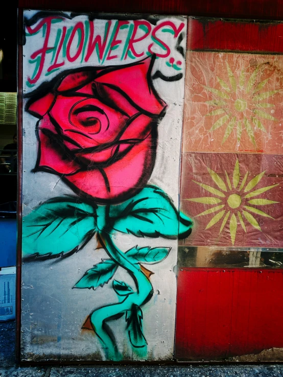 a rose painted on a red, white and green wall with graffiti