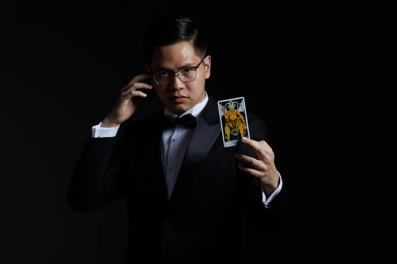 man in tuxedo with cards and phone