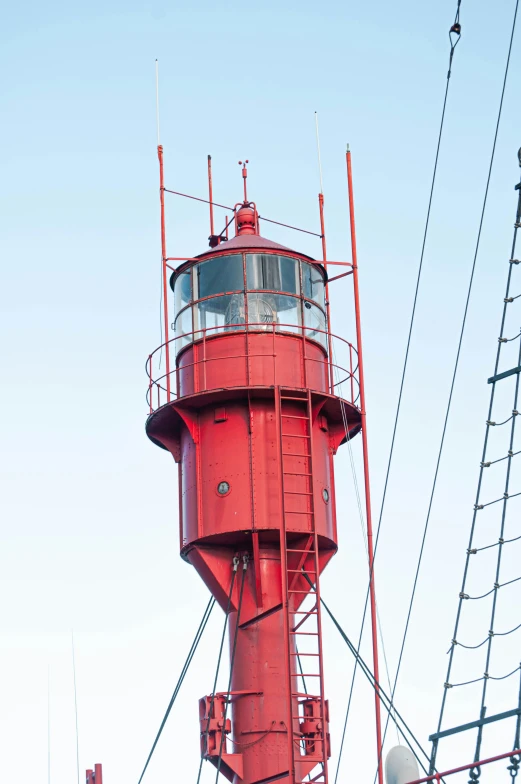 a red lighthouse with a weather vein on top