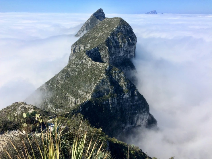 the top of a mountain with low cloud in the background