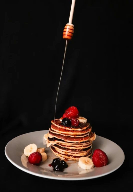 the pancakes are arranged on a plate with fruits and syrup