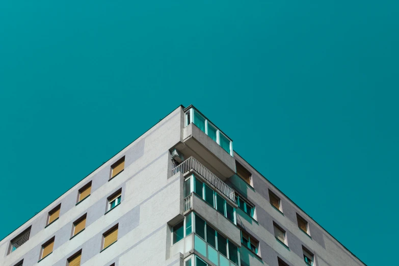 the top of a tall building that has windows and balconies