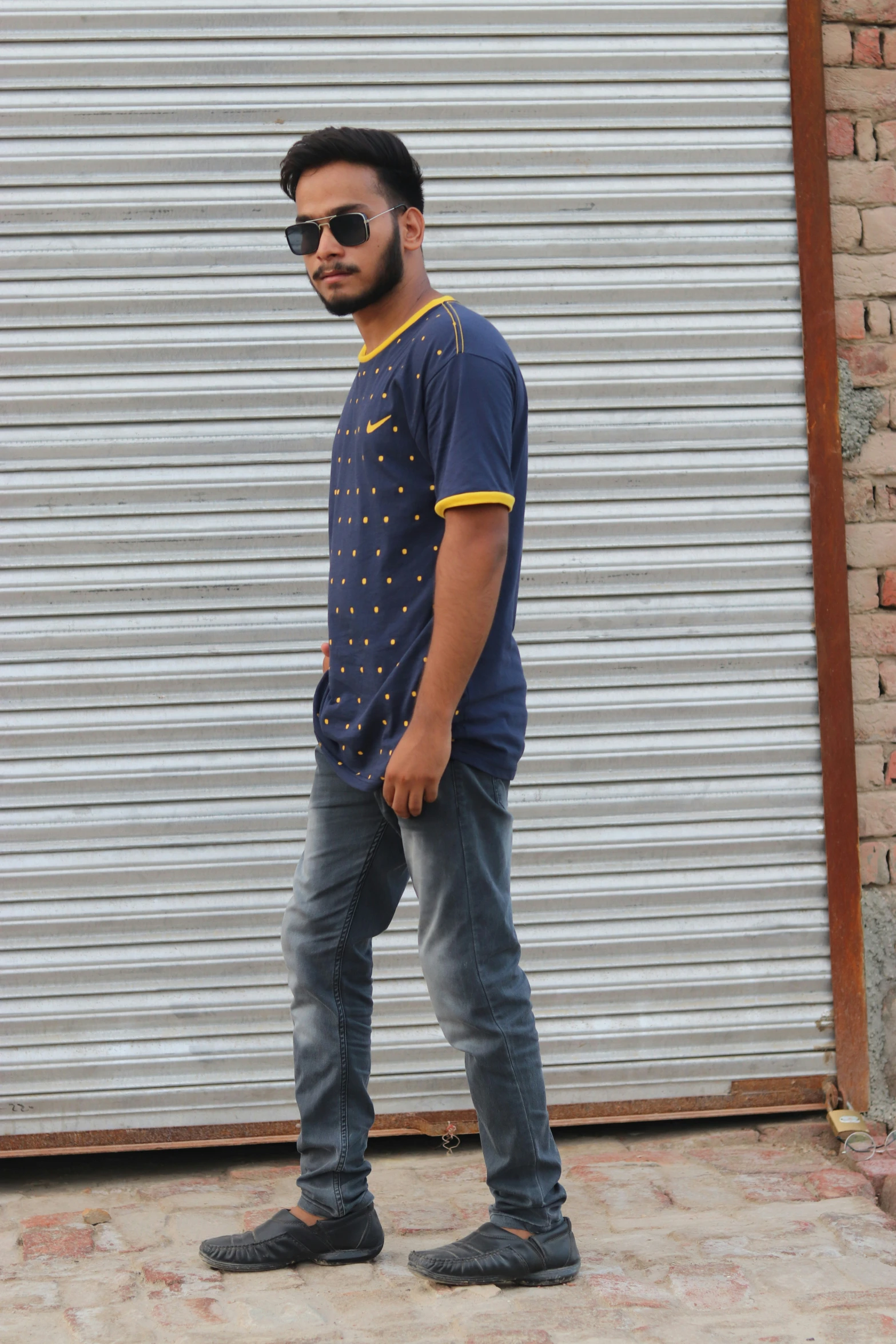 a man with sunglasses standing next to a building