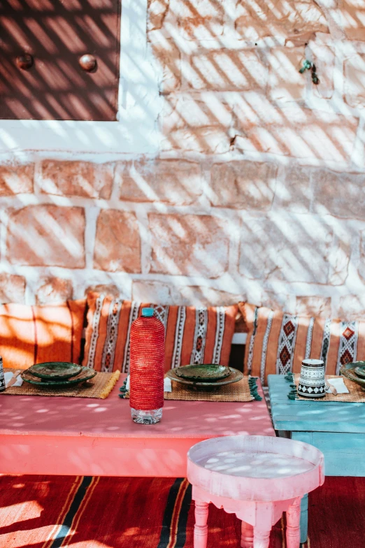 an outdoor setting with a table, chairs and a colorful cloth