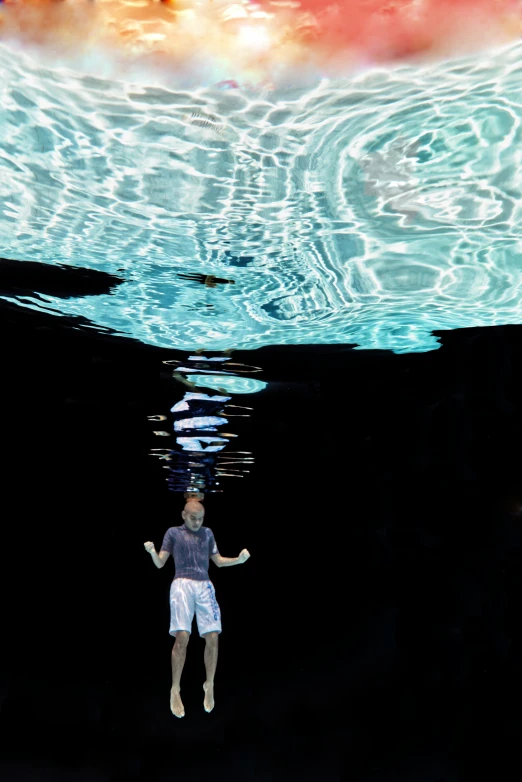 a man in black shirt standing under water