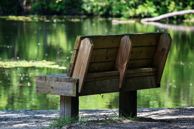 a bench on the side of a pond